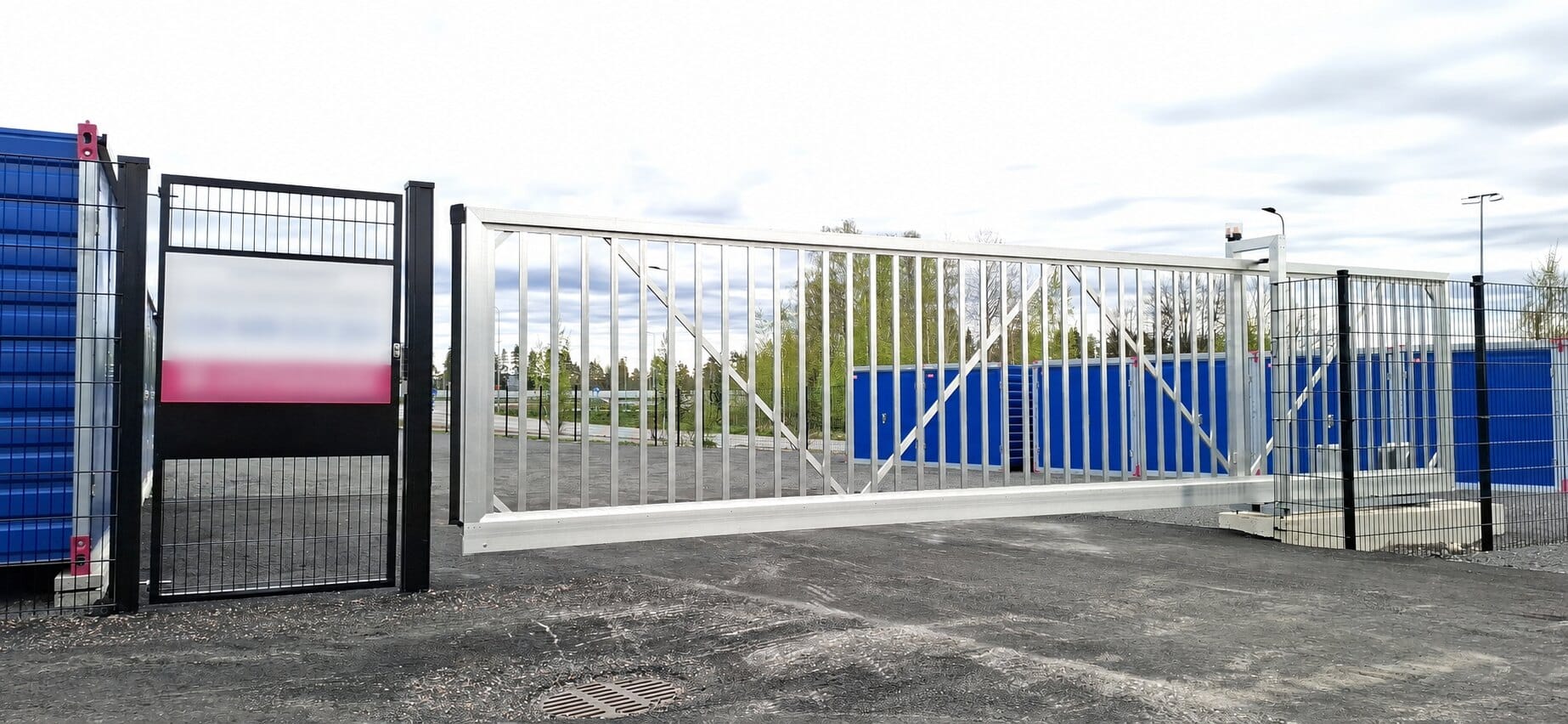 Konekäyttöinen alumiininen liukuportti GSM-ohjauksella varastoalueella Palokassa Jyväskylässä